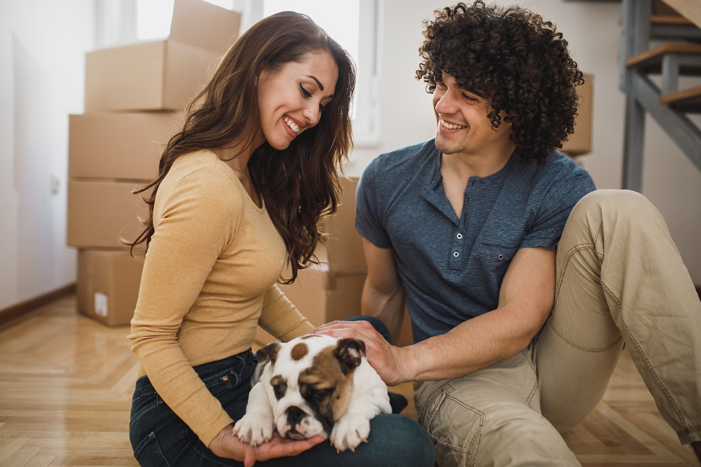 Happy couple at home with their new puppy